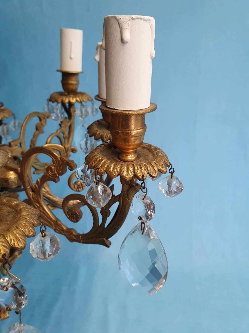 An eight-arm brass ceiling chandelier featuring candle-effect light fittings and suspended crystal glass drops. View II