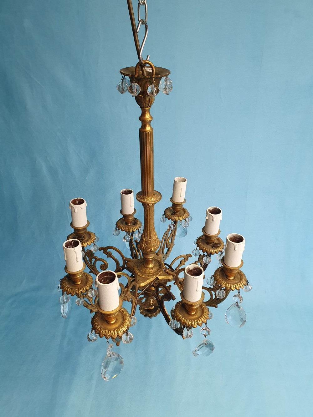 An eight-arm brass ceiling chandelier featuring candle-effect light fittings and suspended crystal glass drops. View III