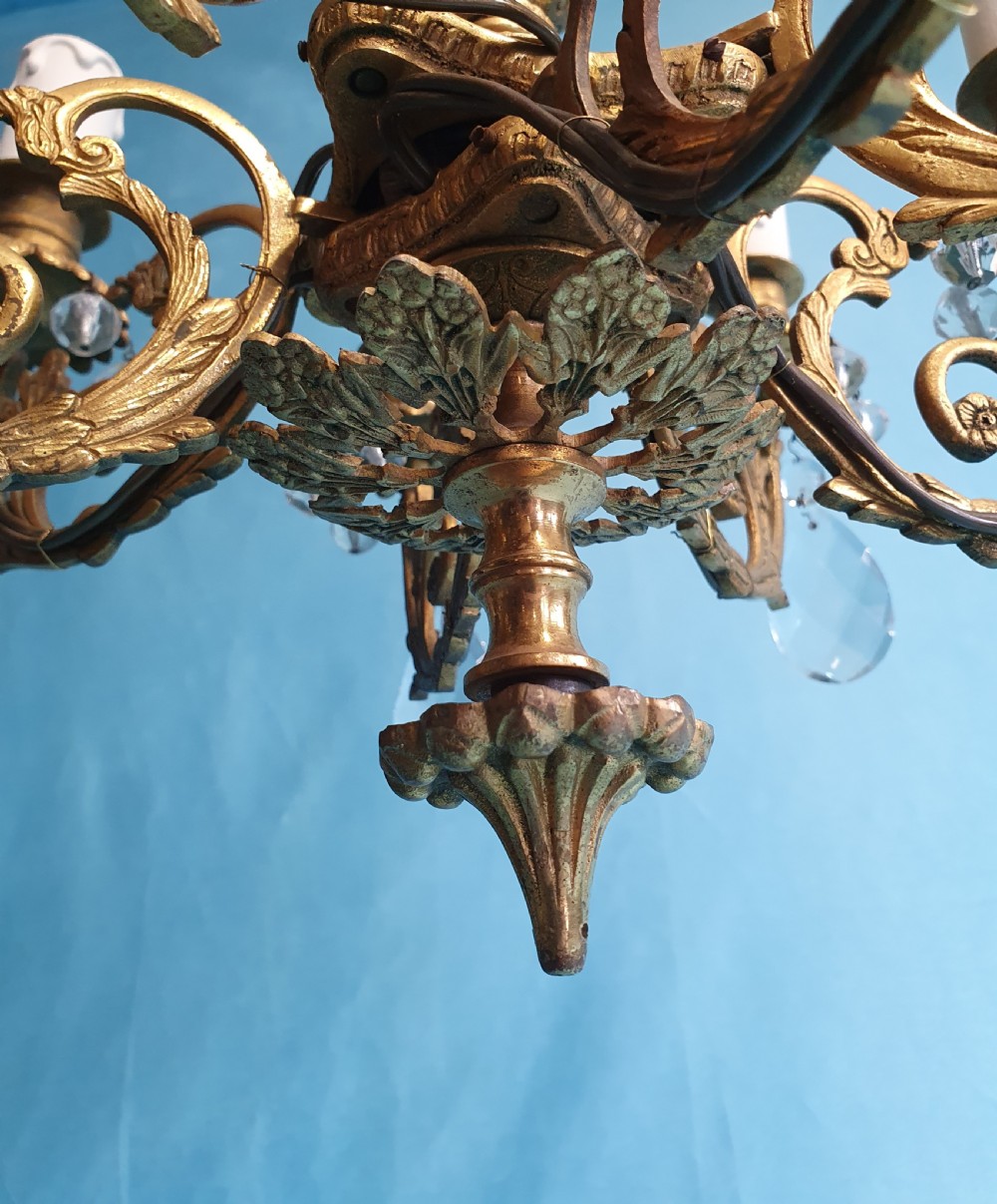 An eight-arm brass ceiling chandelier featuring candle-effect light fittings and suspended crystal glass drops. View VI