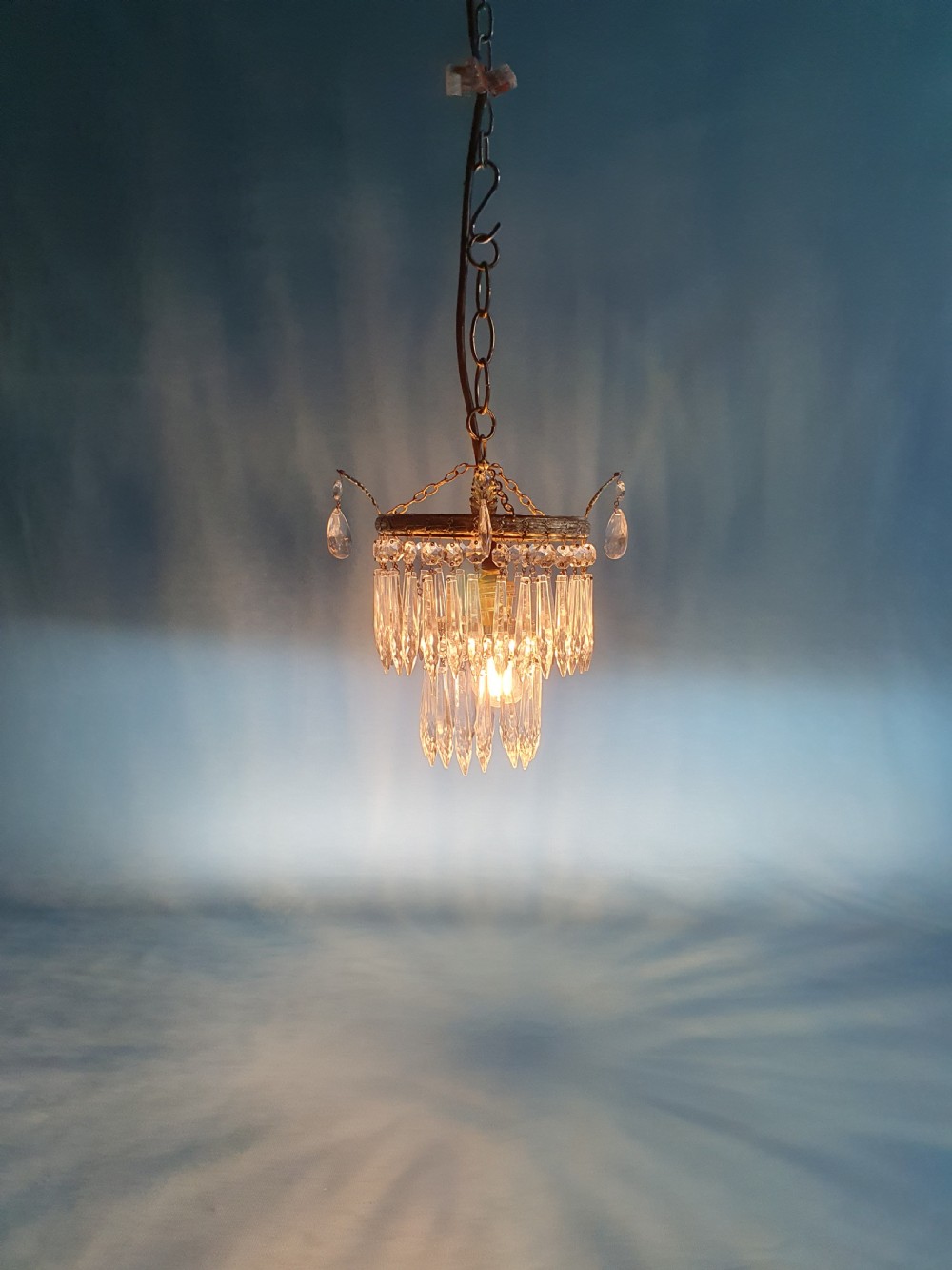 An early 20th-century gilt brass and cut glass crystal spike pendant chandelier with cascading tiers of pointed droplets. View II