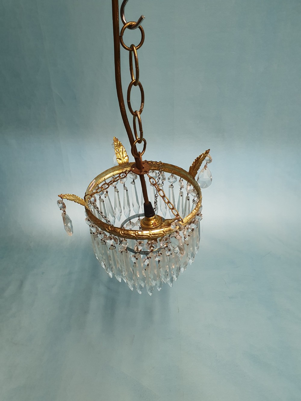 An early 20th-century gilt brass and cut glass crystal spike pendant chandelier with cascading tiers of pointed droplets. View III
