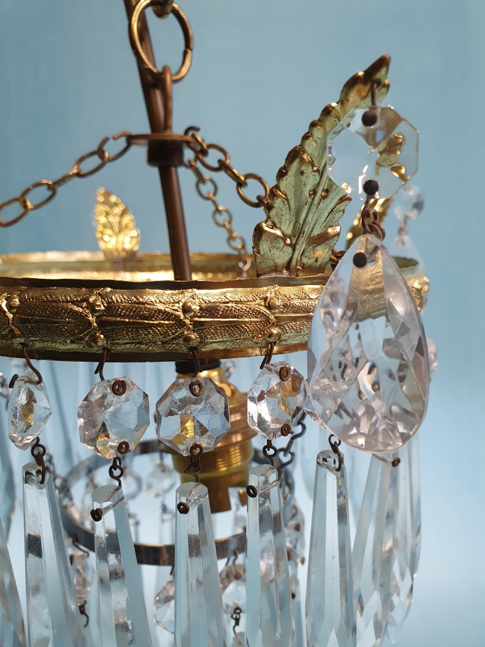 An early 20th-century gilt brass and cut glass crystal spike pendant chandelier with cascading tiers of pointed droplets. View VI