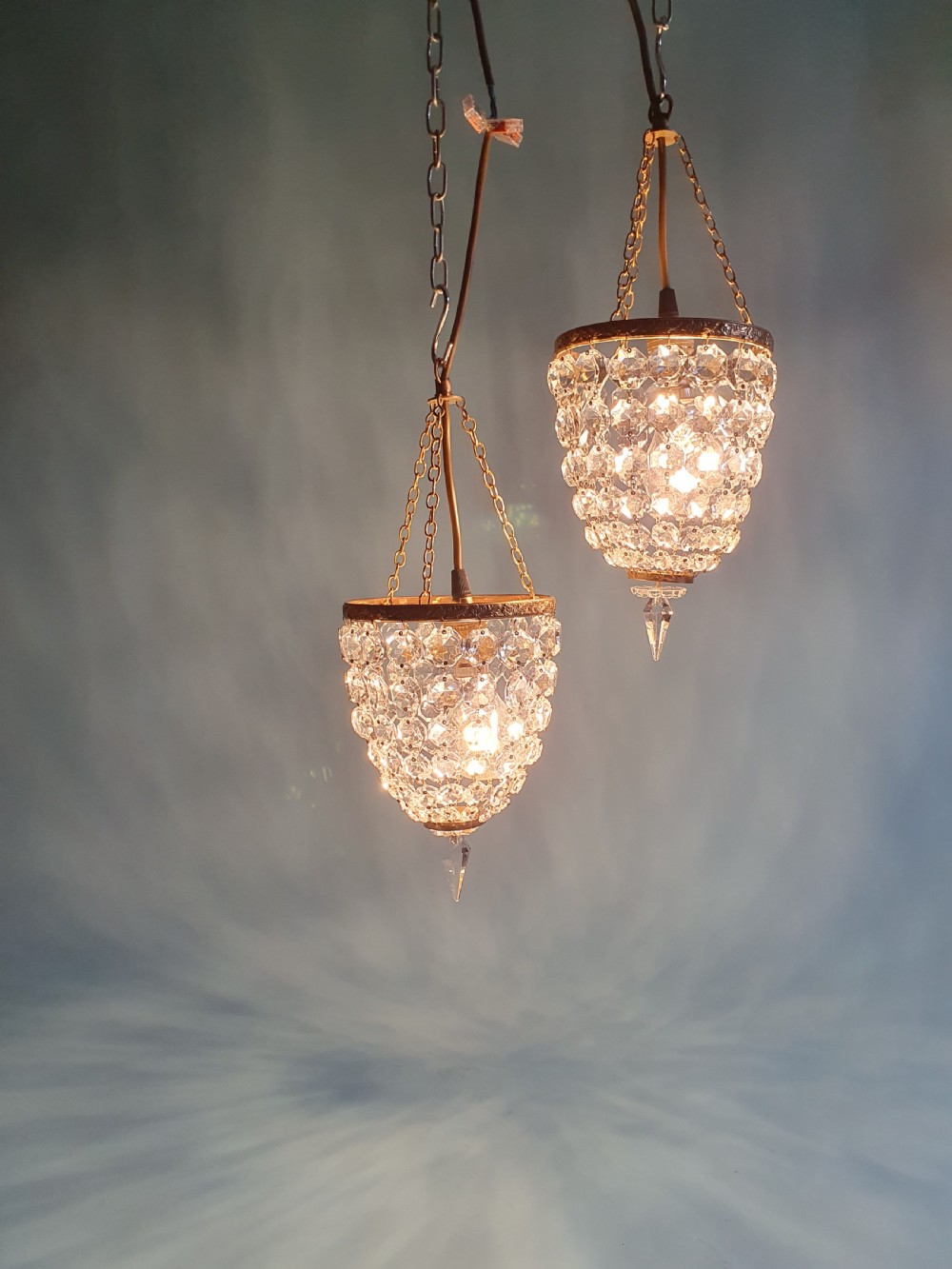A pair of small early 20th-century bag chandeliers featuring brass rims decorated with linked glass crystal beads and lower teardrop prisms. View II