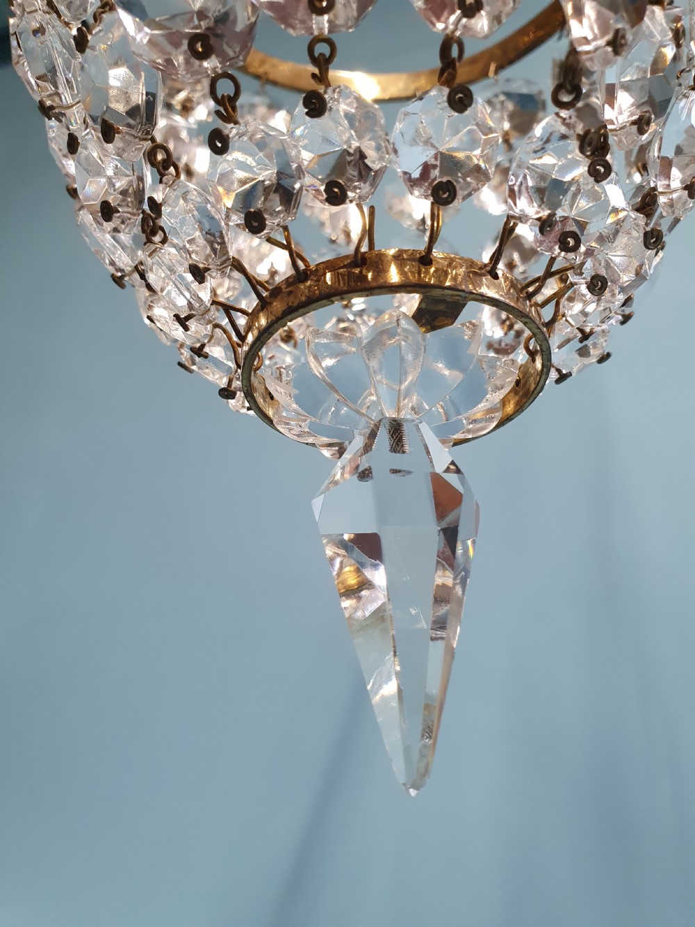 A pair of small early 20th-century bag chandeliers featuring brass rims decorated with linked glass crystal beads and lower teardrop prisms. View V