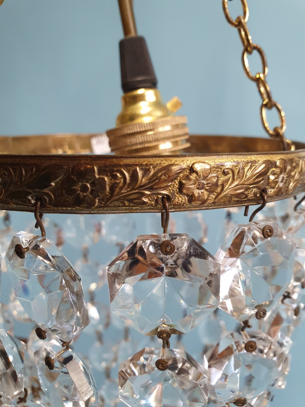 A pair of small early 20th-century bag chandeliers featuring brass rims decorated with linked glass crystal beads and lower teardrop prisms. View VI