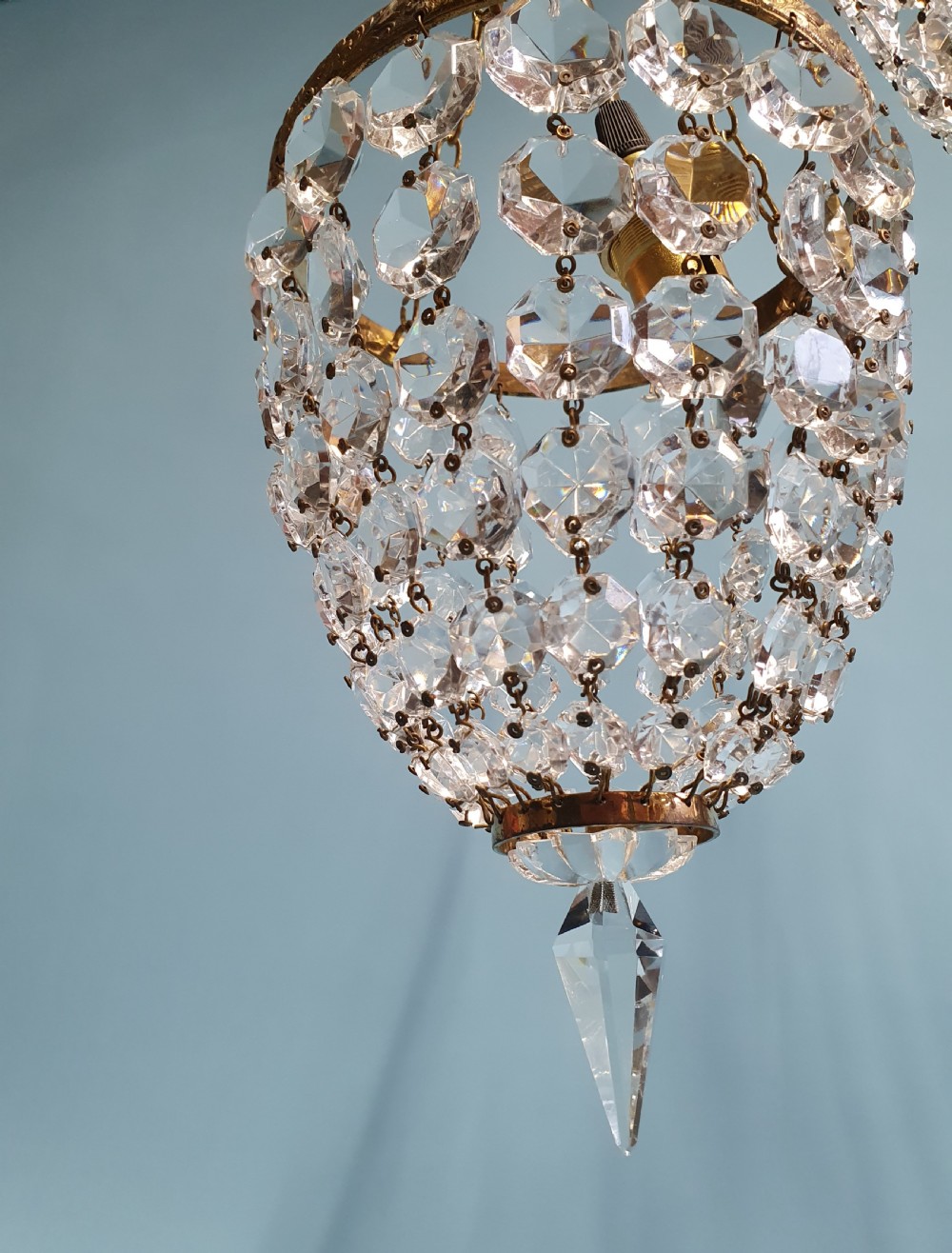 A pair of small early 20th-century bag chandeliers featuring brass rims decorated with linked glass crystal beads and lower teardrop prisms. View VII