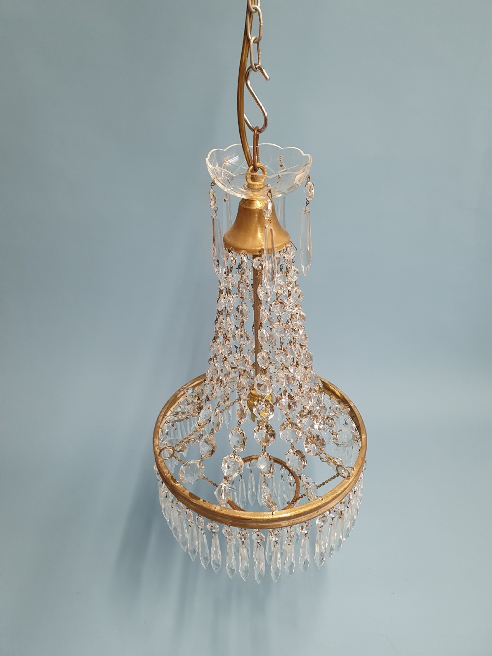 An early 20th-century ceiling chandelier featuring a tent of cascading crystal beads ending at a brass ring hung with vertical crystal spike drops. View II