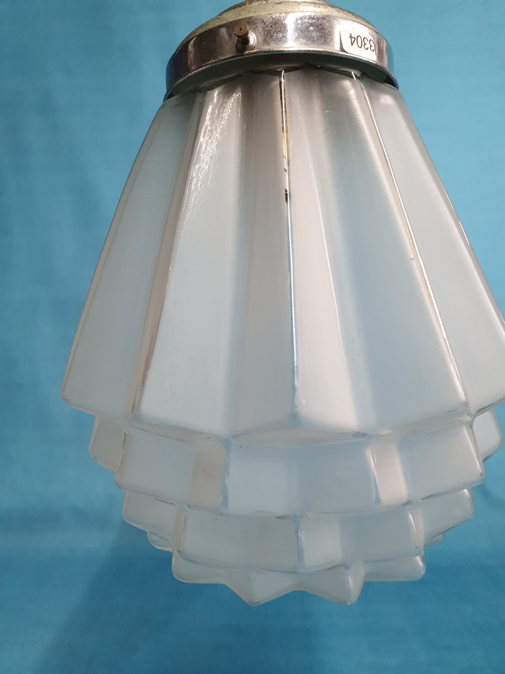 A frosted white Art Deco glass pendant light shade featuring a geometric stepped design suspended by a metal chain. View III