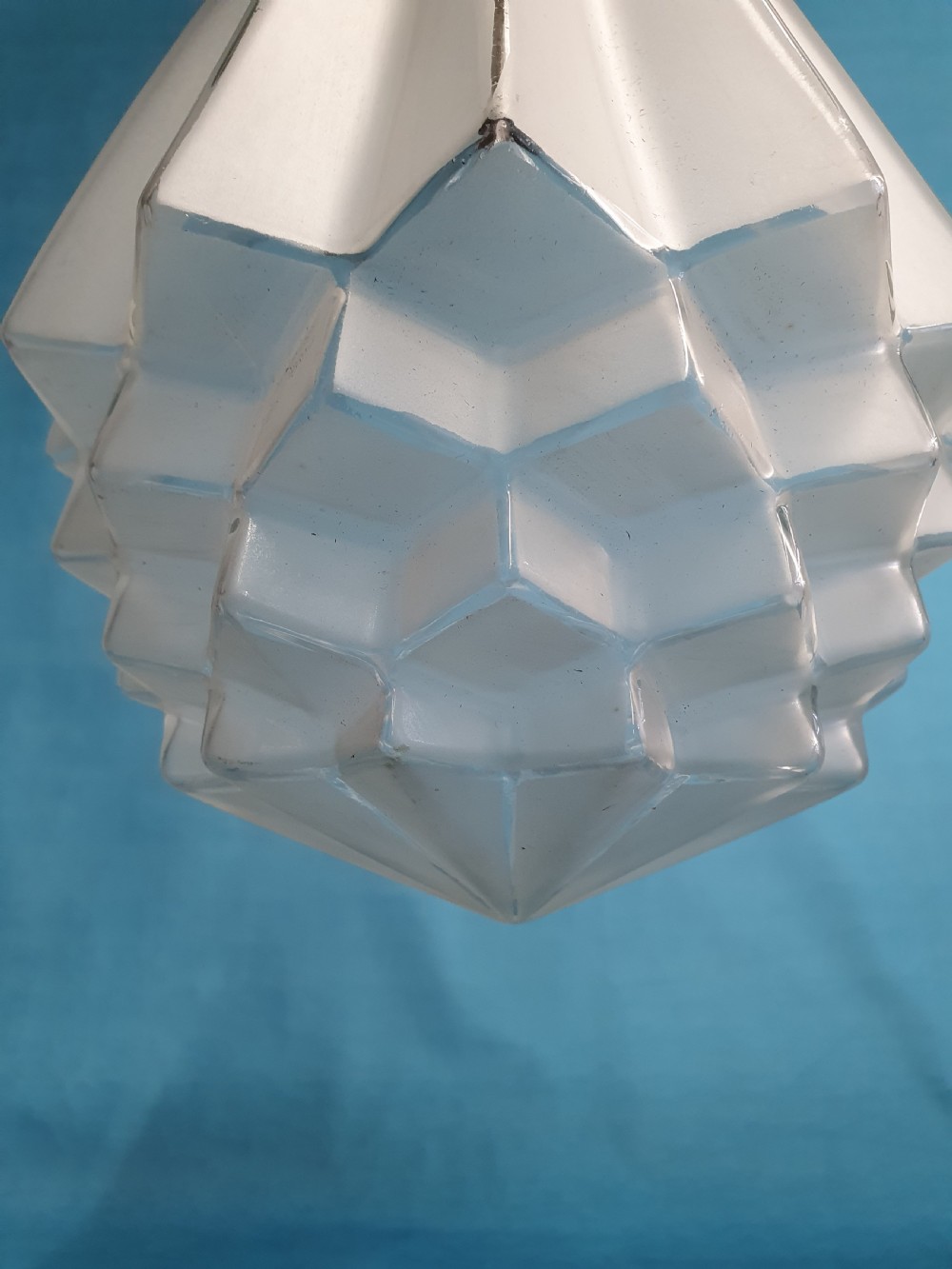 A frosted white Art Deco glass pendant light shade featuring a geometric stepped design suspended by a metal chain. View IX