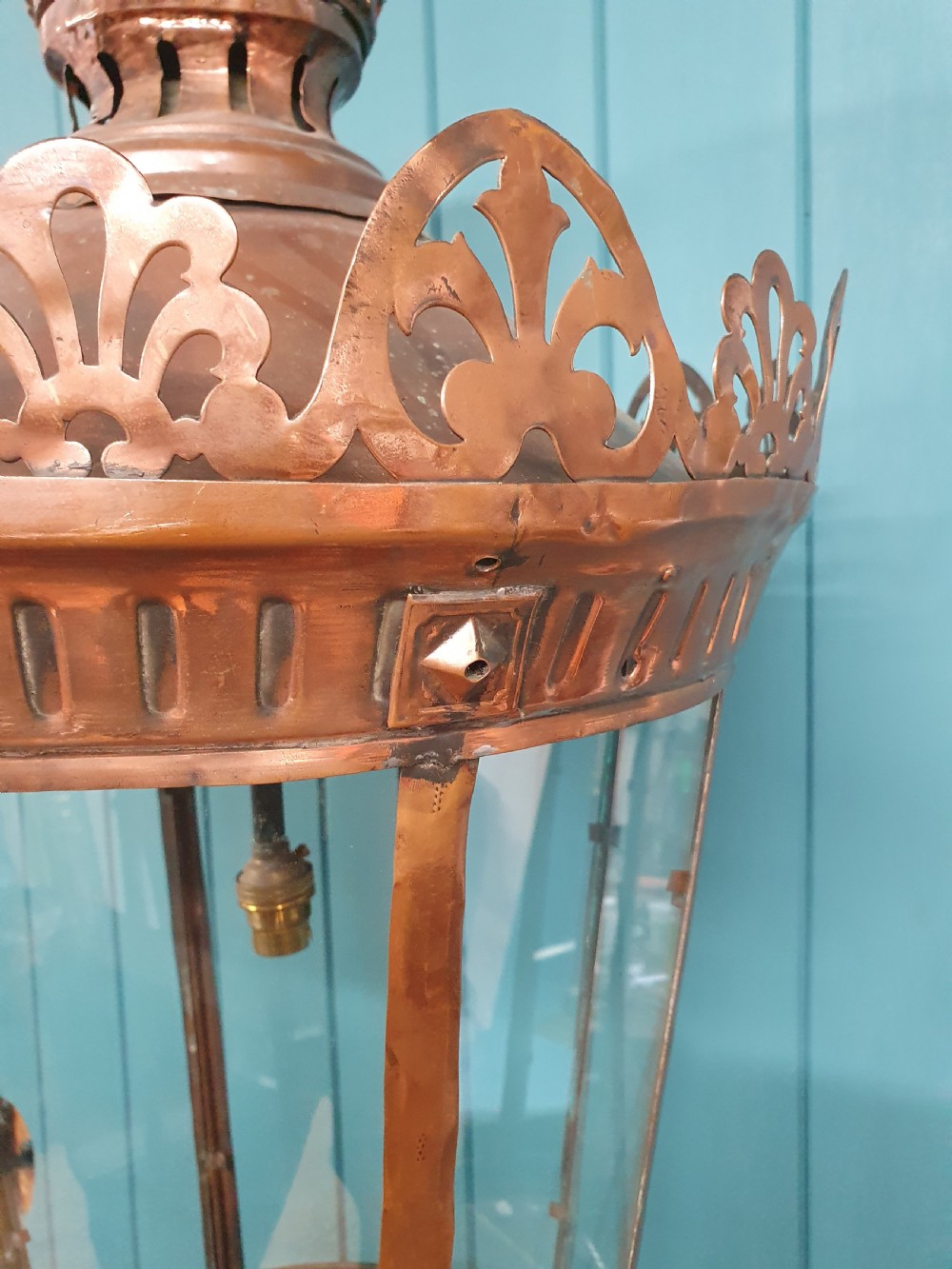 A large circular antique copper lantern with clear glass panels, decorative pierced gallery trim, and suspension chain. View V