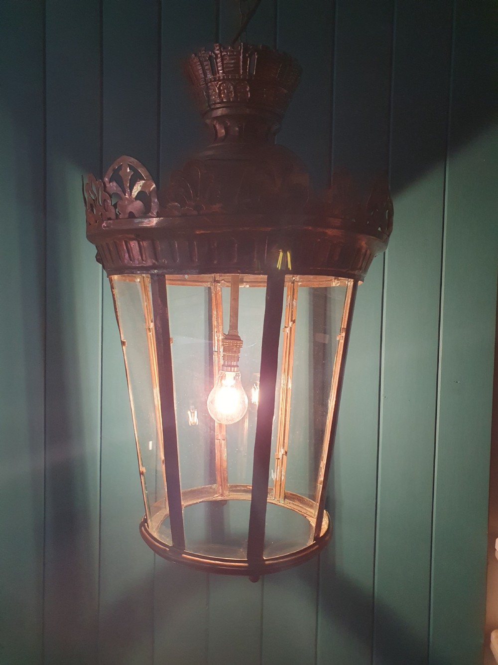 A large circular antique copper lantern with clear glass panels, decorative pierced gallery trim, and suspension chain. View VIII