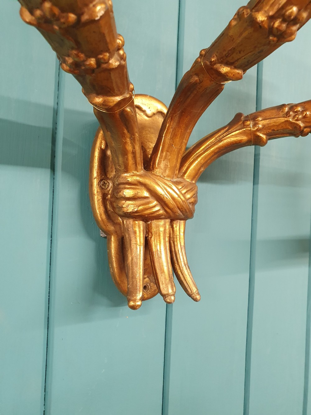 A pair of three-arm gilt metal French wall sconces designed to resemble tied organic branches, fitted with cream candle-drip sleeves. View II
