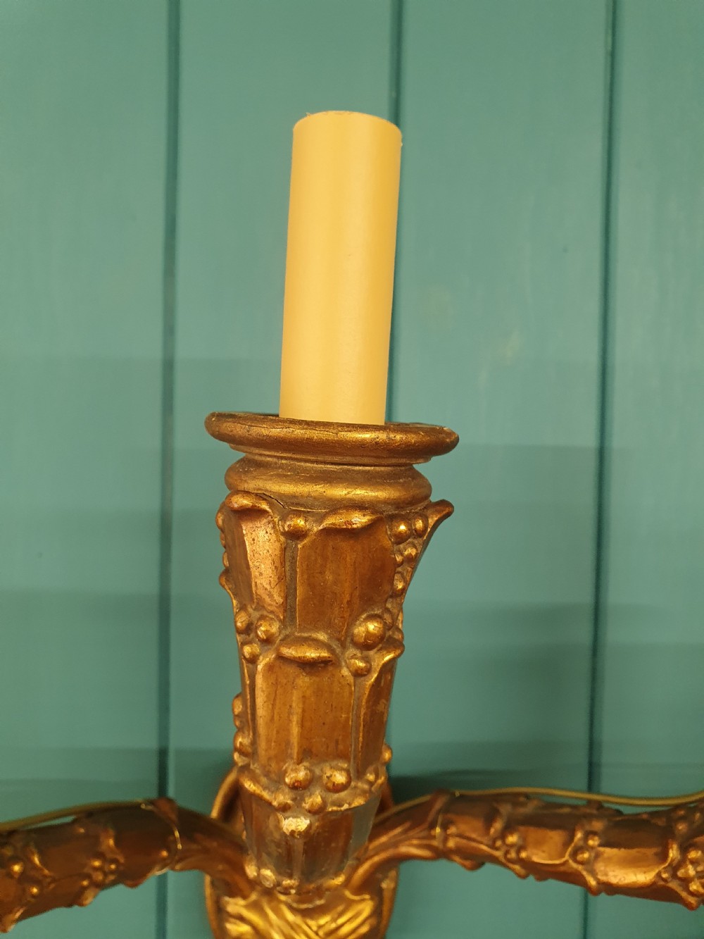 A pair of three-arm gilt metal French wall sconces designed to resemble tied organic branches, fitted with cream candle-drip sleeves. View III
