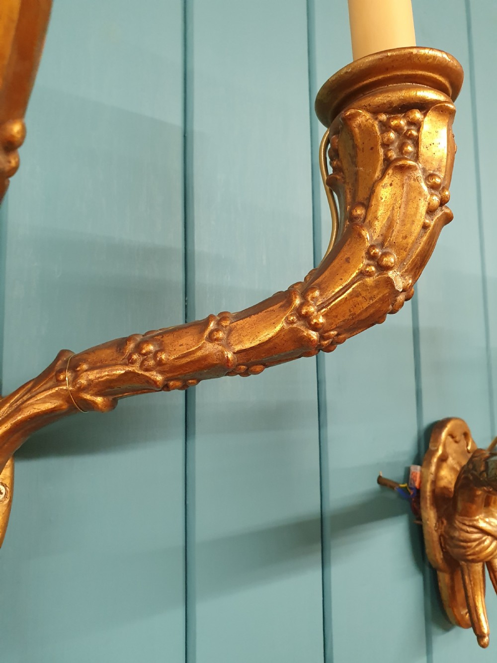 A pair of three-arm gilt metal French wall sconces designed to resemble tied organic branches, fitted with cream candle-drip sleeves. View VIII
