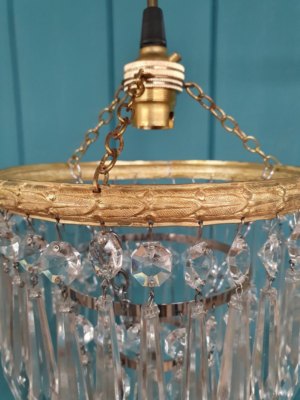 A pair of early 20th century light fixtures featuring gilt brass circular rings with suspended concentric tiers of pointed clear crystal glass prisms. View II