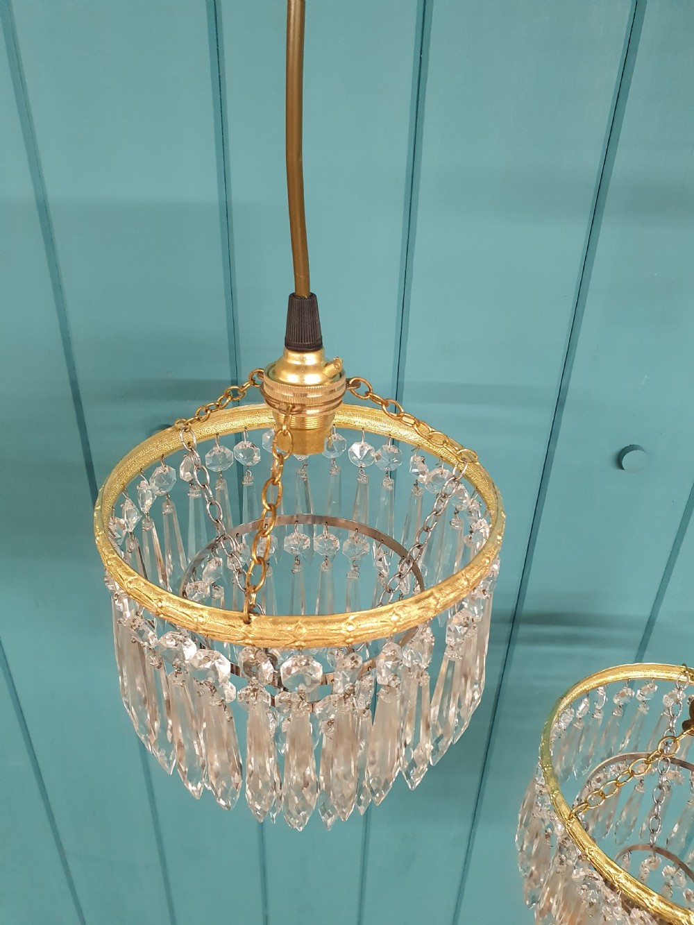 A pair of early 20th century light fixtures featuring gilt brass circular rings with suspended concentric tiers of pointed clear crystal glass prisms. View IV