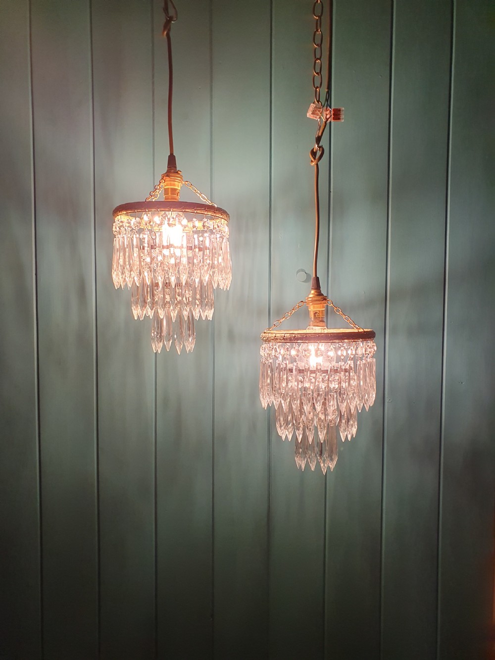 A pair of early 20th century light fixtures featuring gilt brass circular rings with suspended concentric tiers of pointed clear crystal glass prisms. View VI