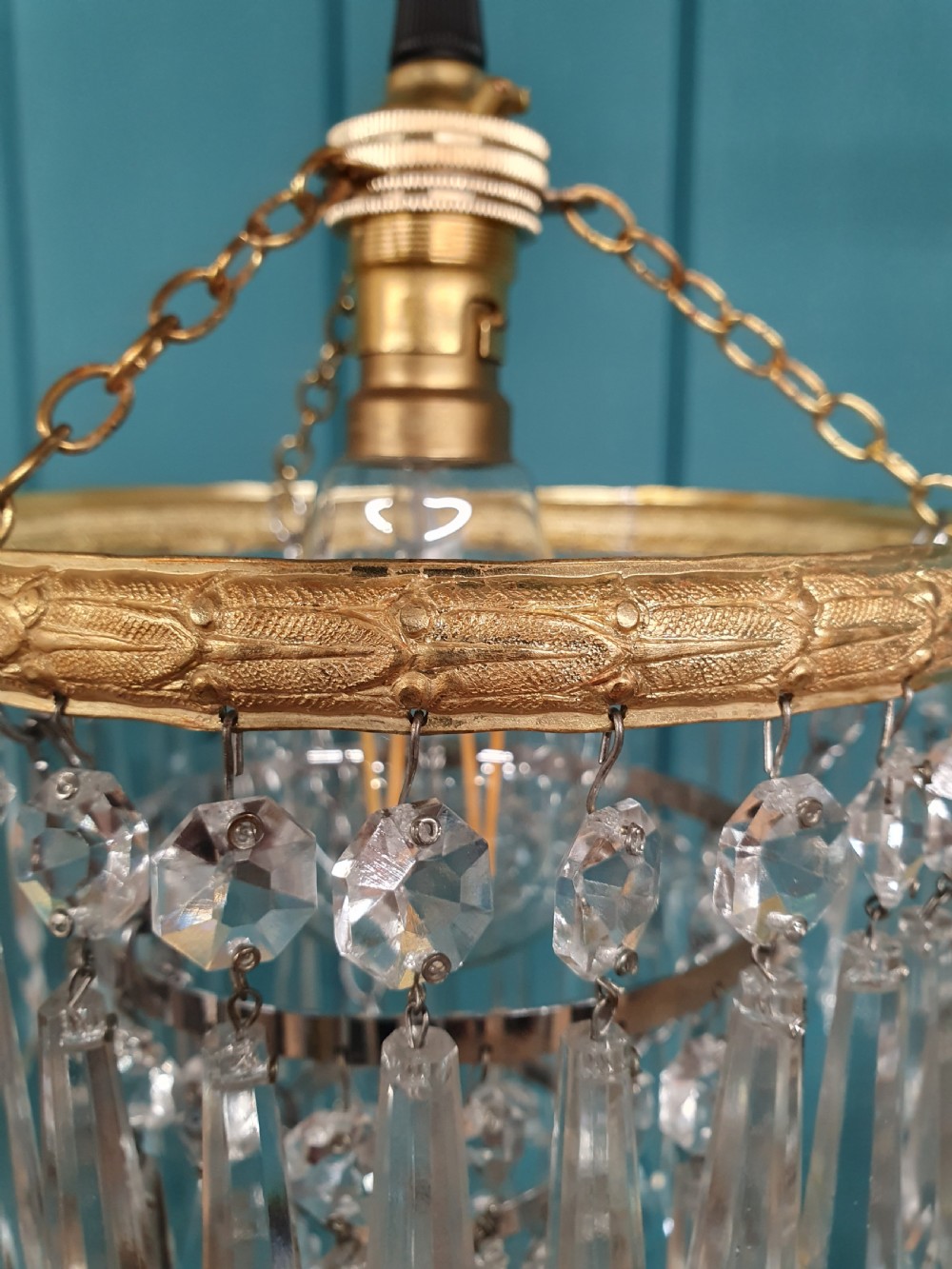 A pair of early 20th century light fixtures featuring gilt brass circular rings with suspended concentric tiers of pointed clear crystal glass prisms. View VII