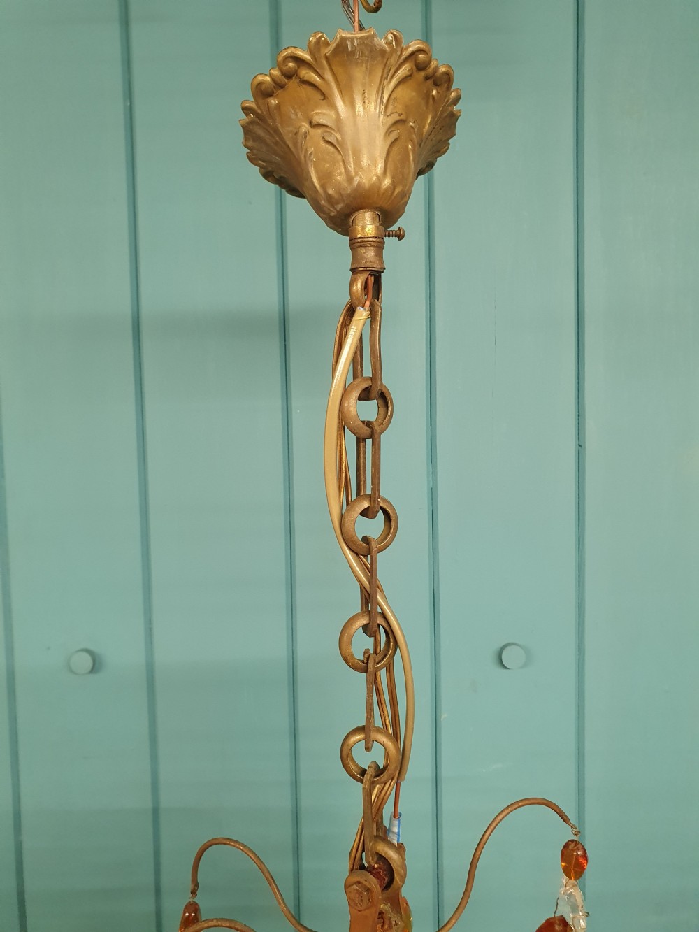 An early 20th century French brass chandelier featuring clear cut crystal droplets, amber glass beads, and candle-sleeve light fittings. View VI