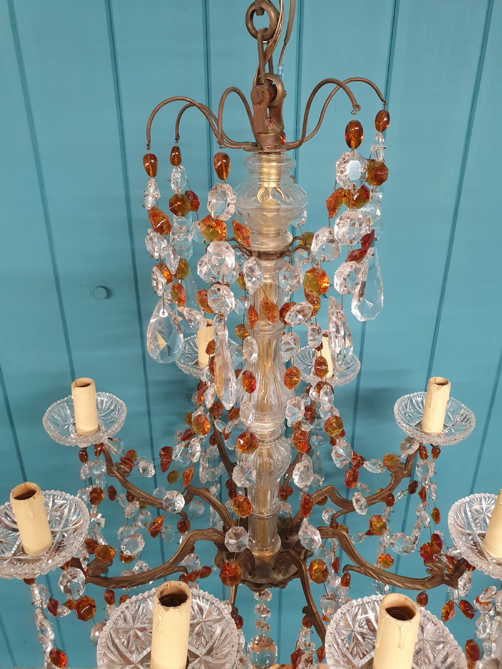 An early 20th century French brass chandelier featuring clear cut crystal droplets, amber glass beads, and candle-sleeve light fittings. View VII
