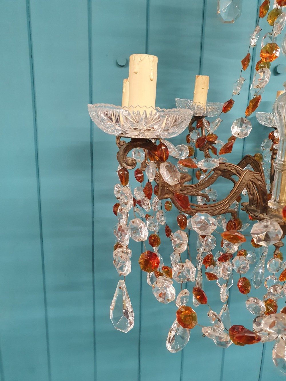 An early 20th century French brass chandelier featuring clear cut crystal droplets, amber glass beads, and candle-sleeve light fittings. View VIII