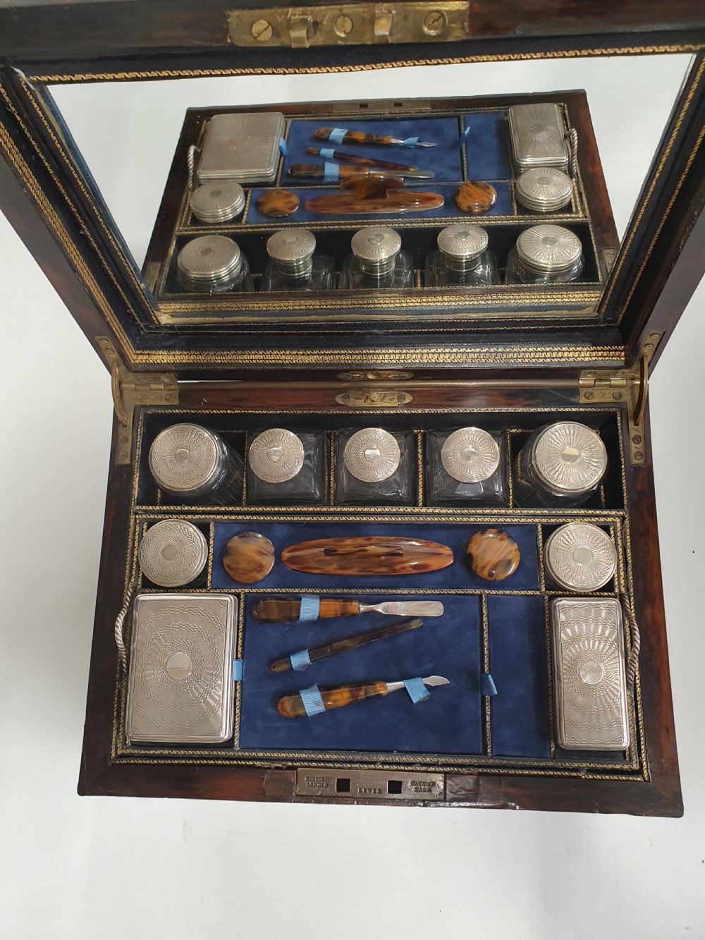A Victorian dark brown coromandel wood dressing box with fine brass stringing, brass edging, and a central brass shield cartouche. View IX