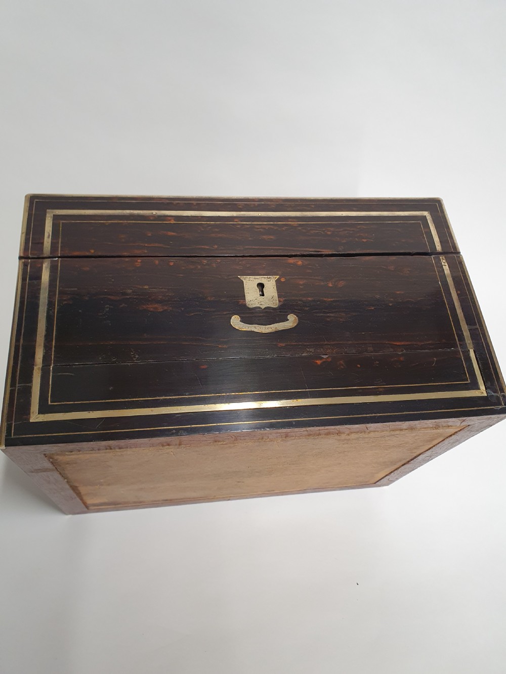 A Victorian dark brown coromandel wood dressing box with fine brass stringing, brass edging, and a central brass shield cartouche. View IV