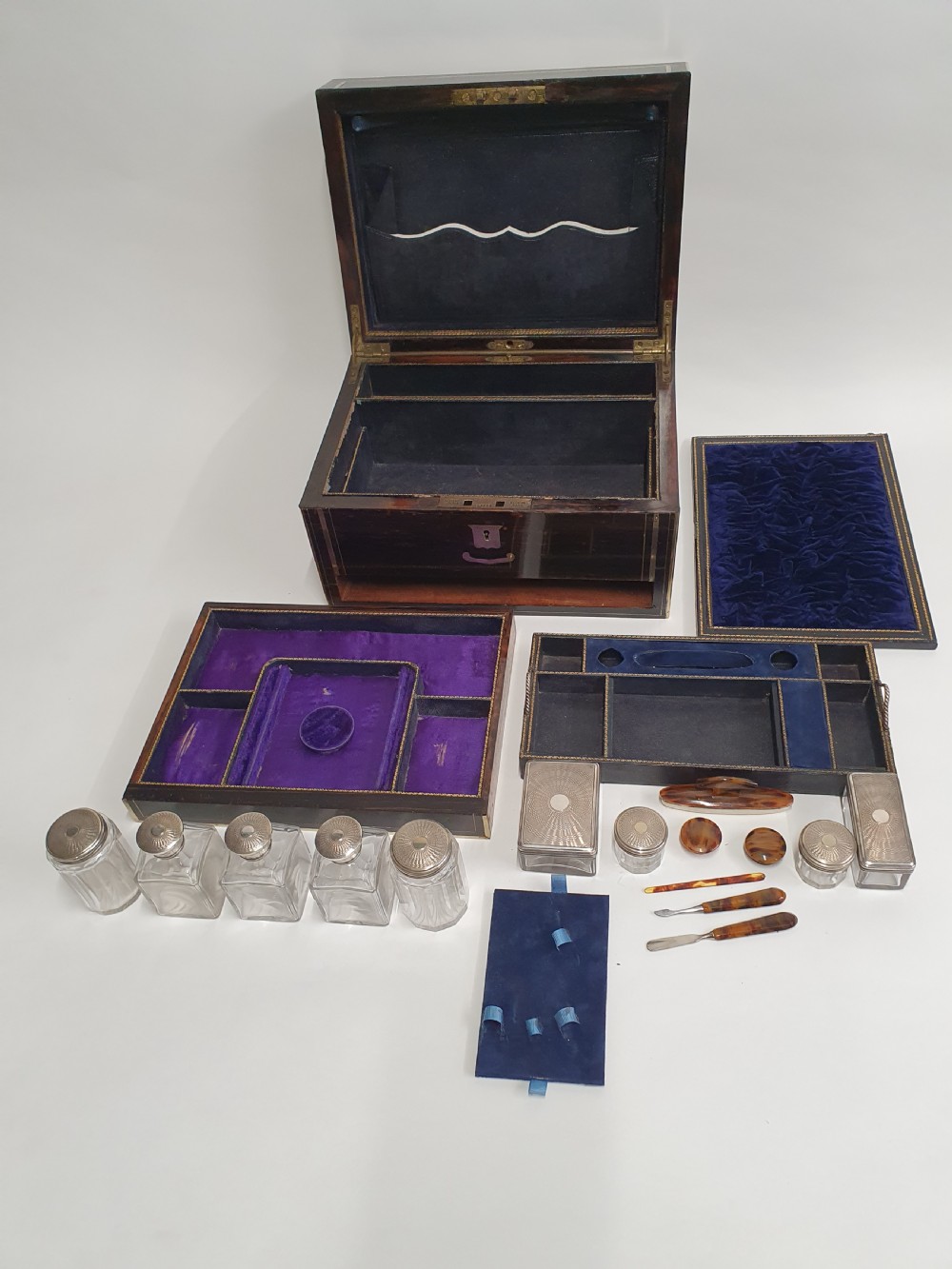 A Victorian dark brown coromandel wood dressing box with fine brass stringing, brass edging, and a central brass shield cartouche. View VII