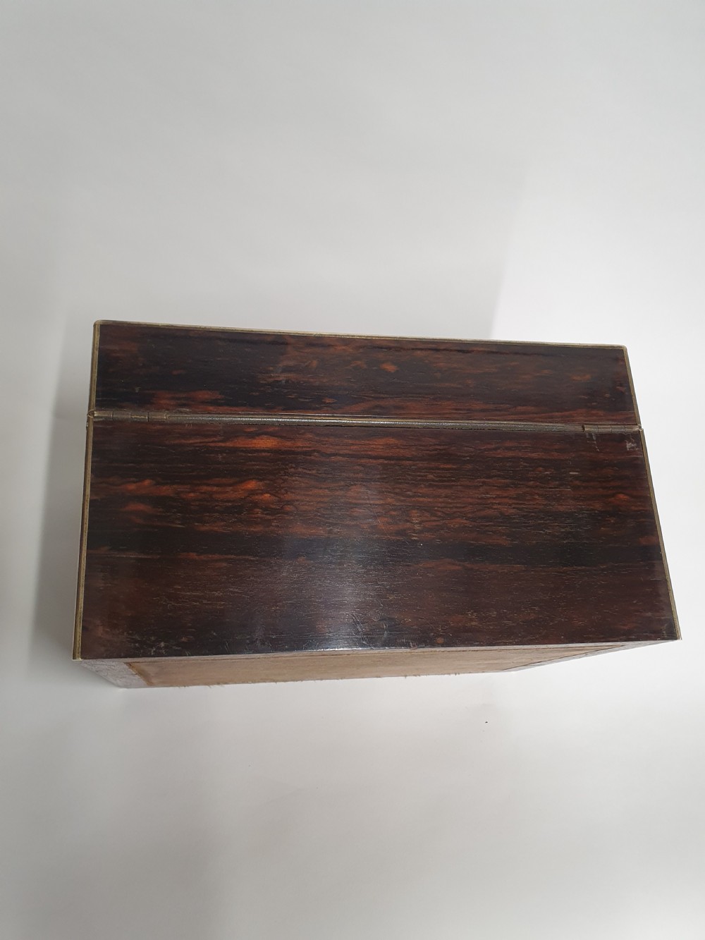 A Victorian dark brown coromandel wood dressing box with fine brass stringing, brass edging, and a central brass shield cartouche. View VIII
