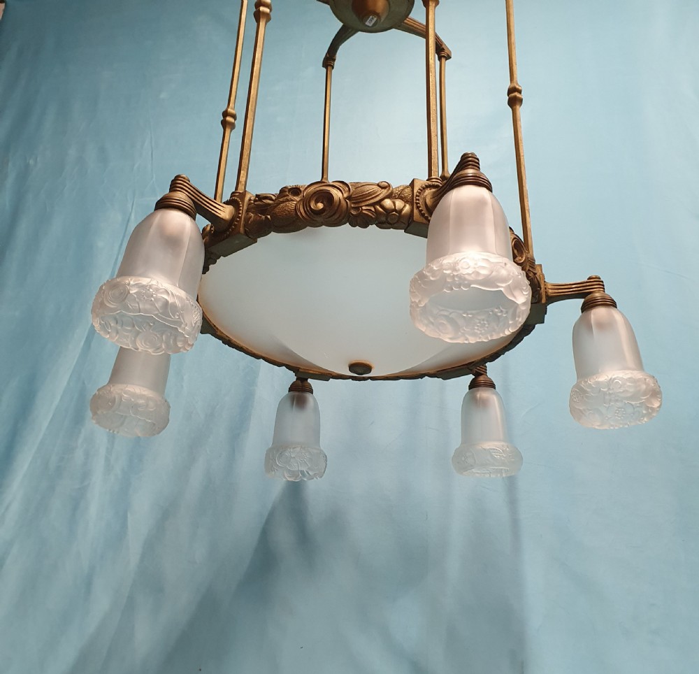 A pair of early 20th-century brass pendant lights featuring tall angular cage frames supporting ornate floral band bases with multiple suspended frosted glass shades. View III