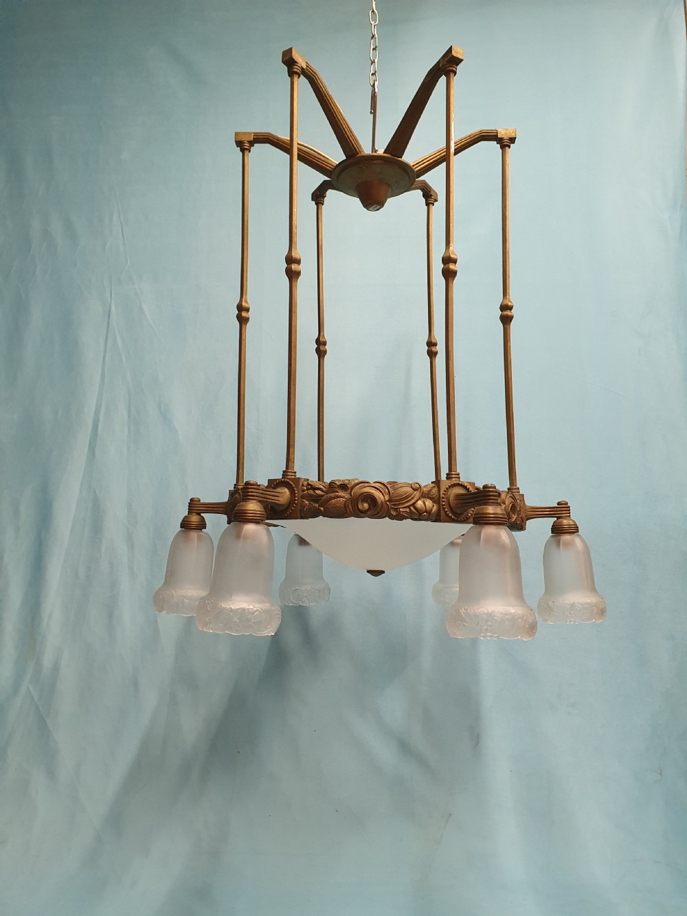 A pair of early 20th-century brass pendant lights featuring tall angular cage frames supporting ornate floral band bases with multiple suspended frosted glass shades. View VIII