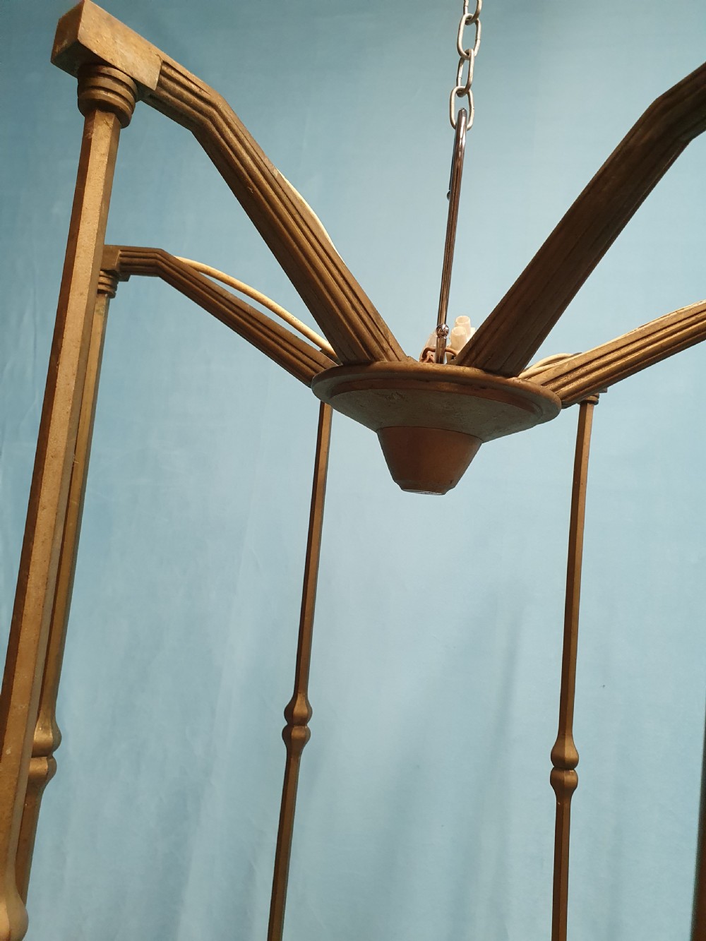 A pair of early 20th-century brass pendant lights featuring tall angular cage frames supporting ornate floral band bases with multiple suspended frosted glass shades. View IX