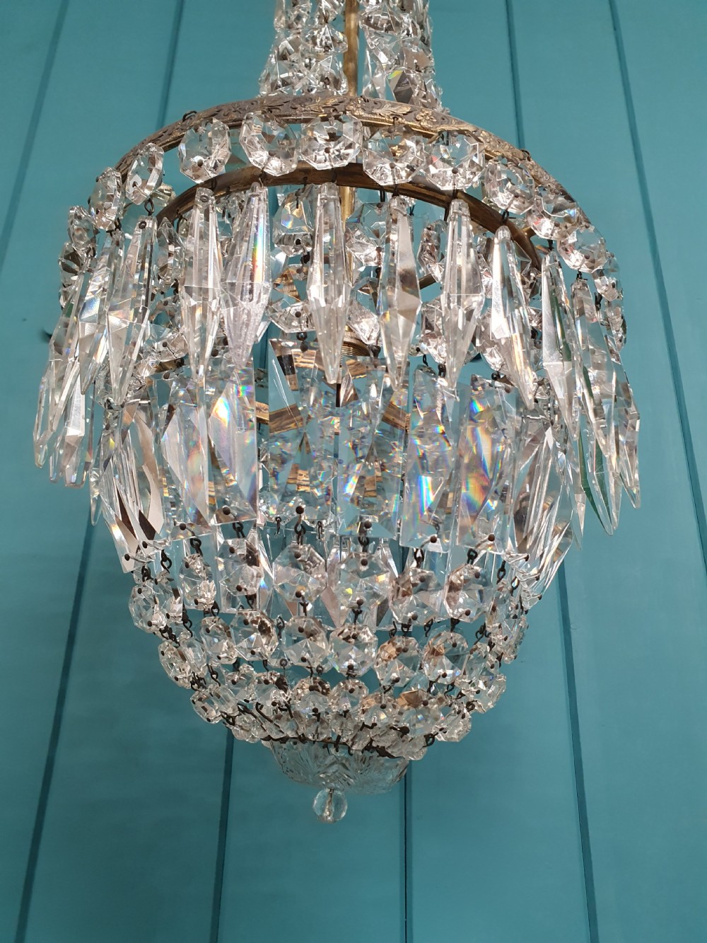 An early 20th-century crystal bag chandelier featuring cascading glass droplets suspended from a decorative brass gallery ring and chain. View II