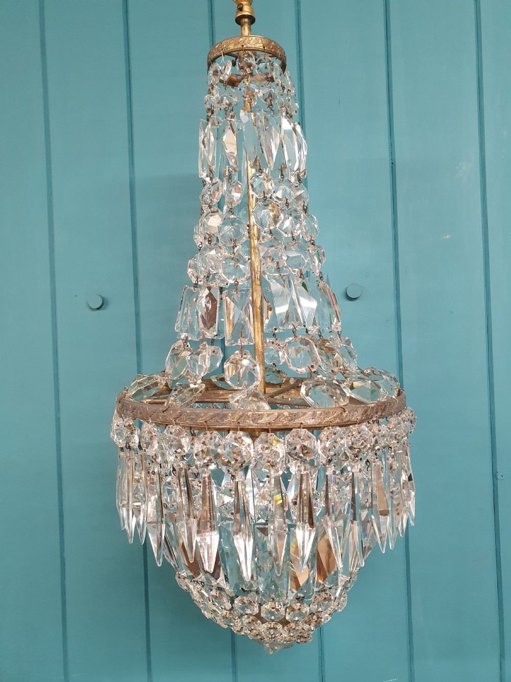 An early 20th-century crystal bag chandelier featuring cascading glass droplets suspended from a decorative brass gallery ring and chain. View III