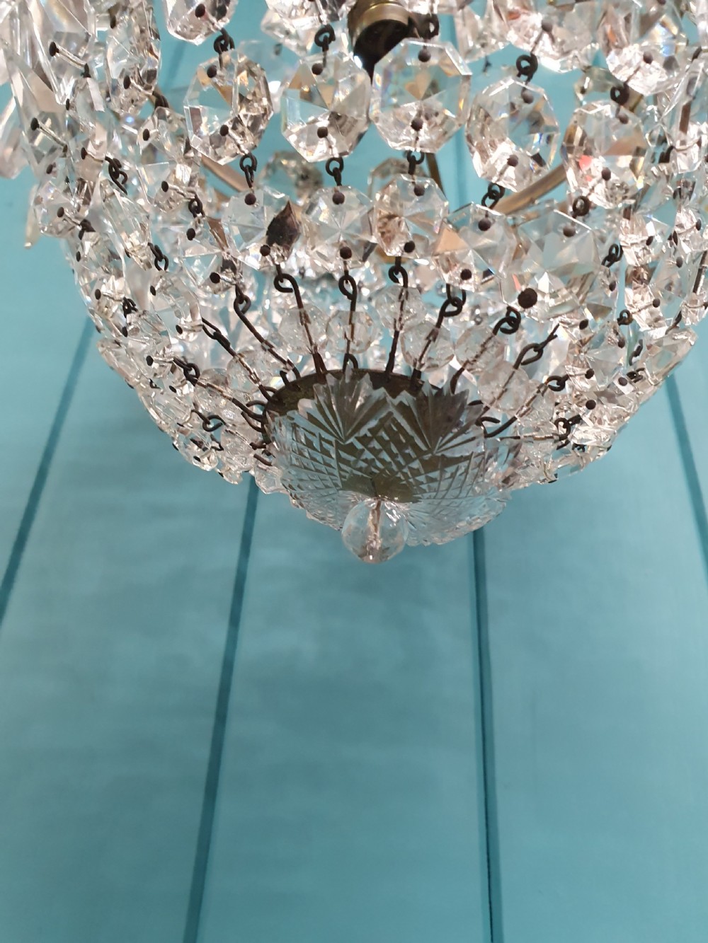 An early 20th-century crystal bag chandelier featuring cascading glass droplets suspended from a decorative brass gallery ring and chain. View VI
