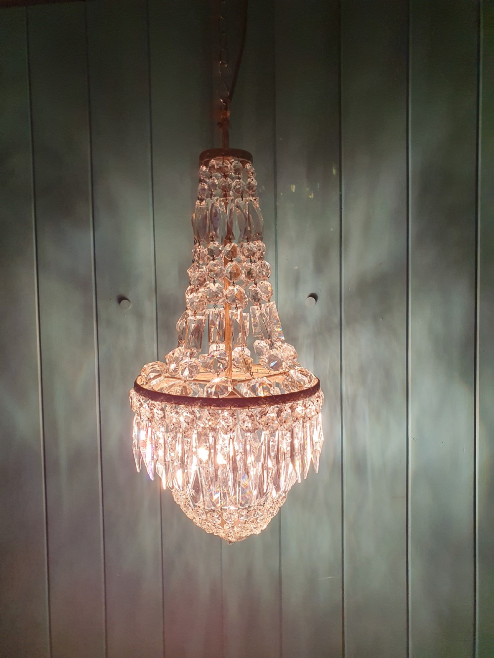 An early 20th-century crystal bag chandelier featuring cascading glass droplets suspended from a decorative brass gallery ring and chain. View VII