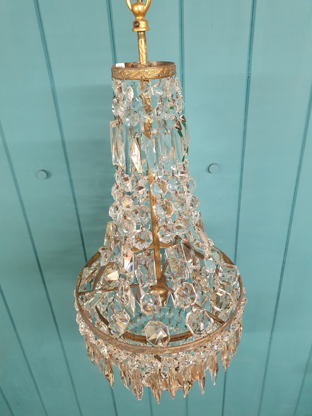 An early 20th-century crystal bag chandelier featuring cascading glass droplets suspended from a decorative brass gallery ring and chain. View VIII