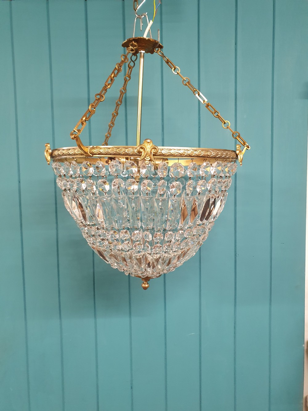 An early twentieth-century brass and cut glass bag basket chandelier with long rectangular prisms and hanging faceted glass drops. View II