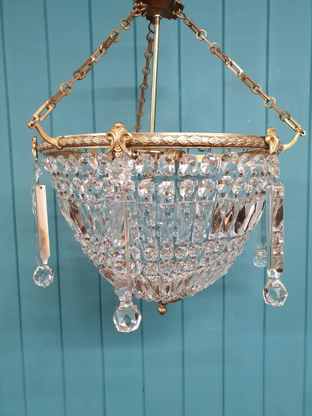 An early twentieth-century brass and cut glass bag basket chandelier with long rectangular prisms and hanging faceted glass drops. View V