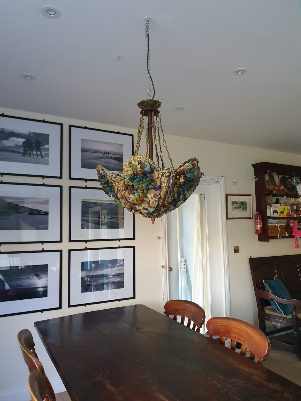 An early 20th-century Continental ceiling chandelier featuring a brass frame decorated with colourful opaque glass grapes and flowers.