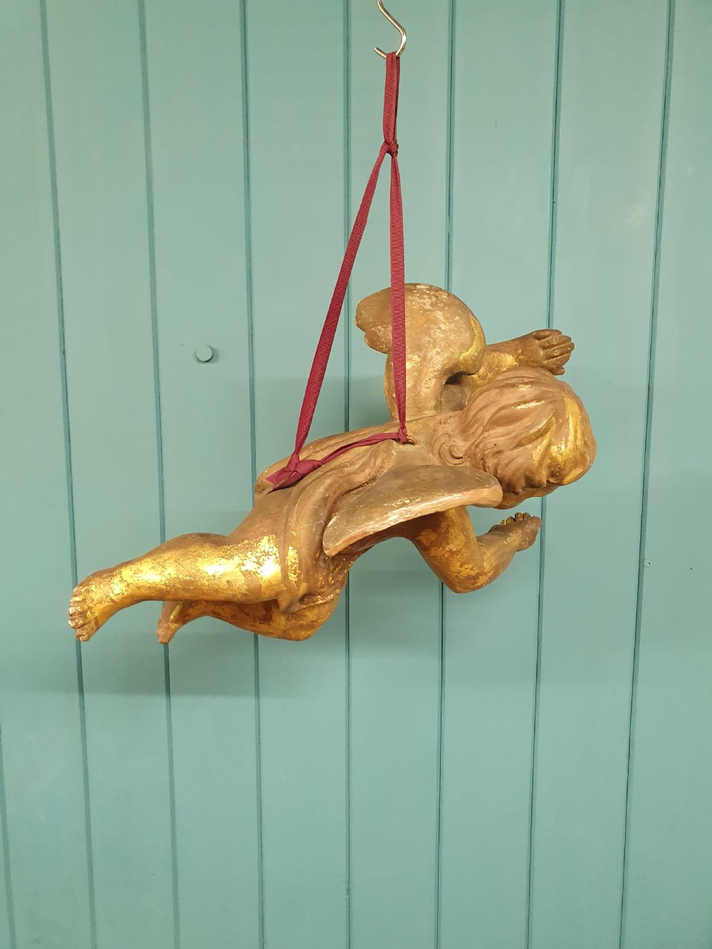A late 19th-century hand-carved wooden cherub figure with feathered wings and extended limbs, finished in gold leaf gilding. View VII