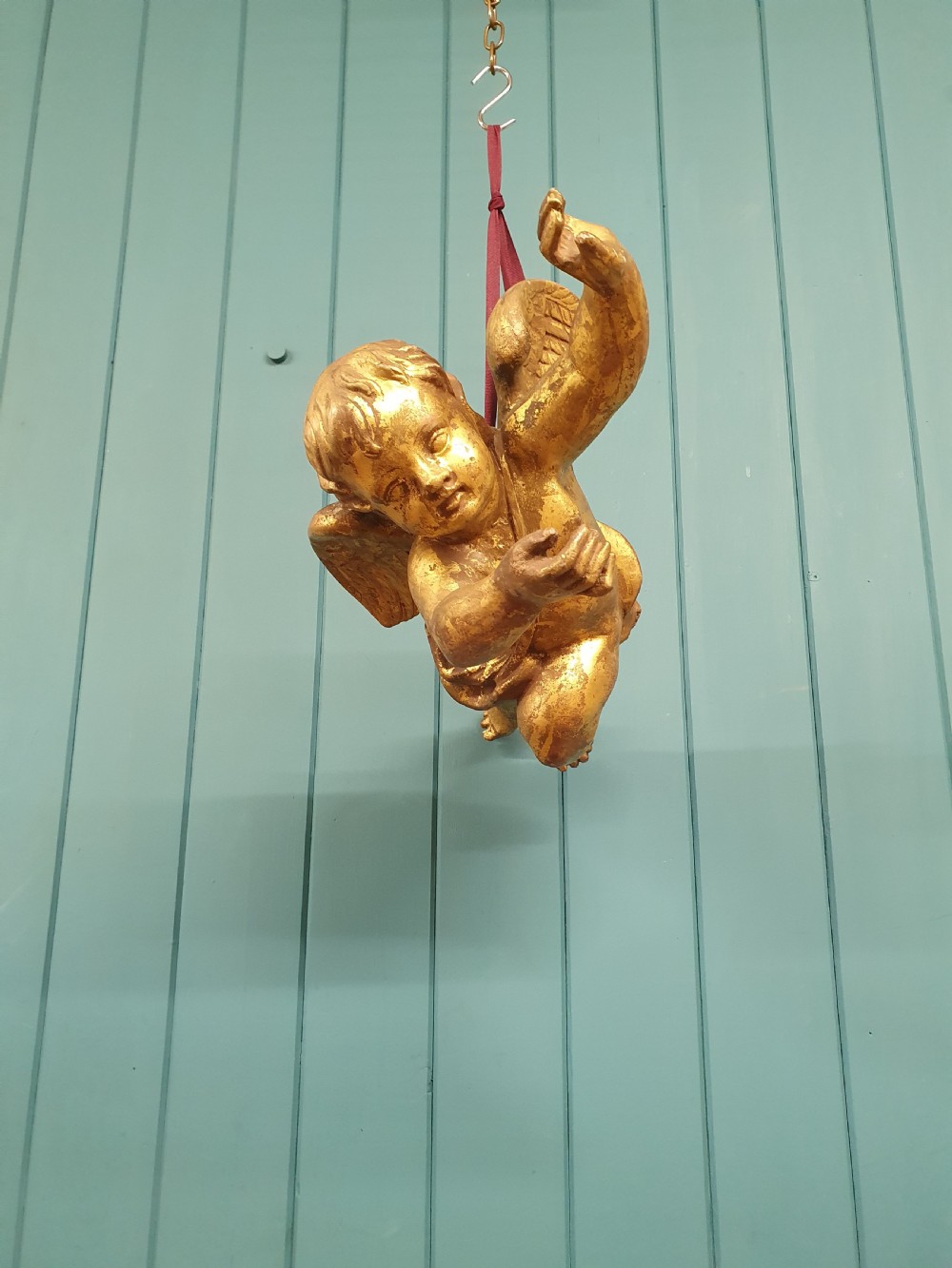 A late 19th-century hand-carved wooden cherub figure with feathered wings and extended limbs, finished in gold leaf gilding. View VIII