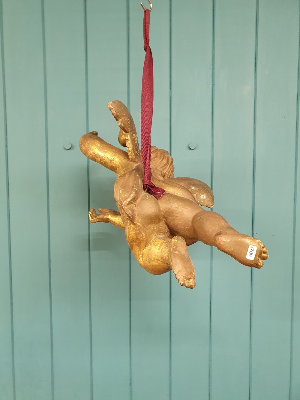 A late 19th-century hand-carved wooden cherub figure with feathered wings and extended limbs, finished in gold leaf gilding. View IX