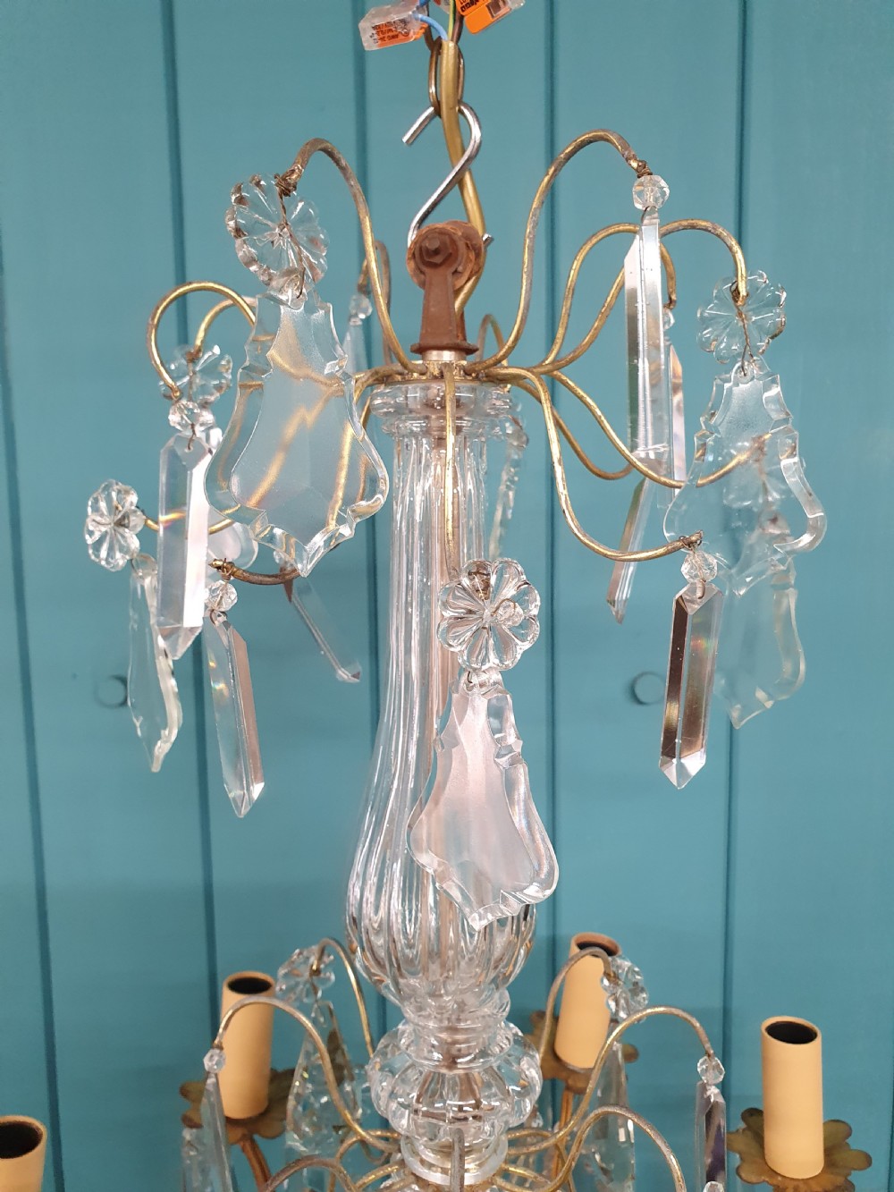 An early twentieth-century French eight-arm glass crystal chandelier featuring a central baluster stem, scrolling metal arms, and suspended cut glass drops. View VIII