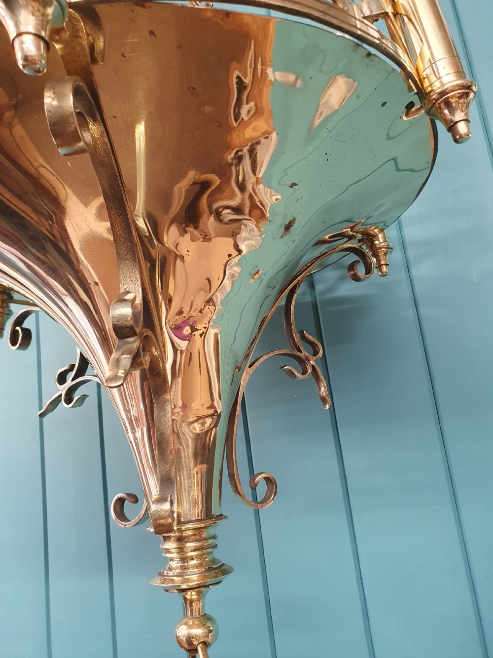 An early twentieth-century Gothic style brass chandelier featuring a pierced geometric gallery, central conical base, and five candle-style bulb holders suspended by chains. View II