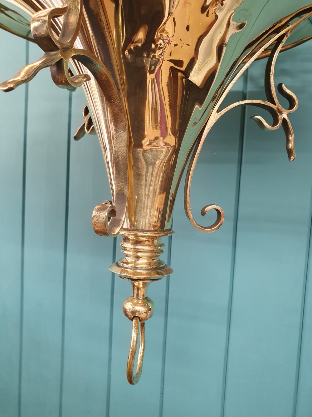 An early twentieth-century Gothic style brass chandelier featuring a pierced geometric gallery, central conical base, and five candle-style bulb holders suspended by chains. View III