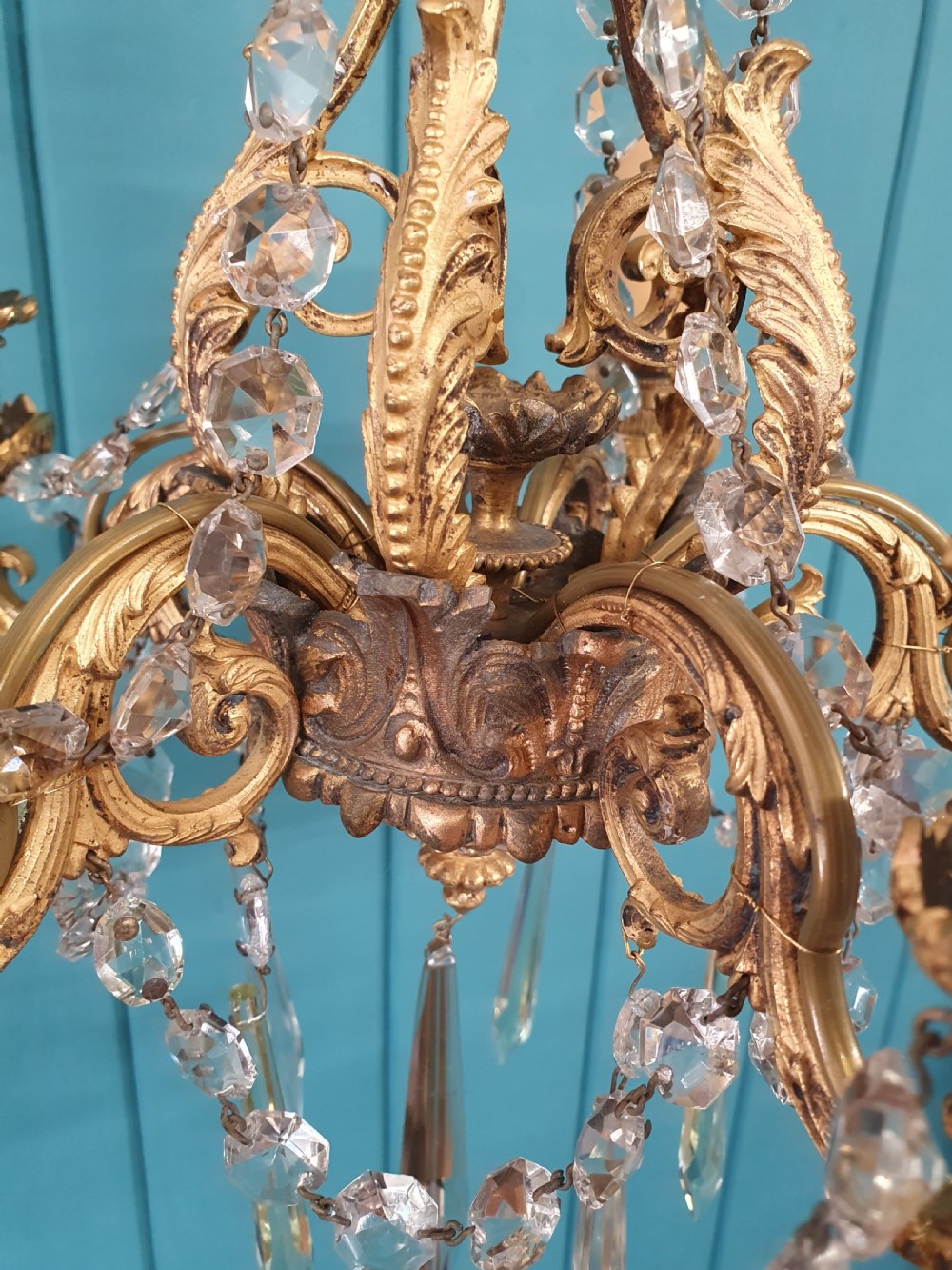 An early 20th-century small gilt brass five-arm chandelier decorated with clear glass crystal swags and teardrop pendants. View VII