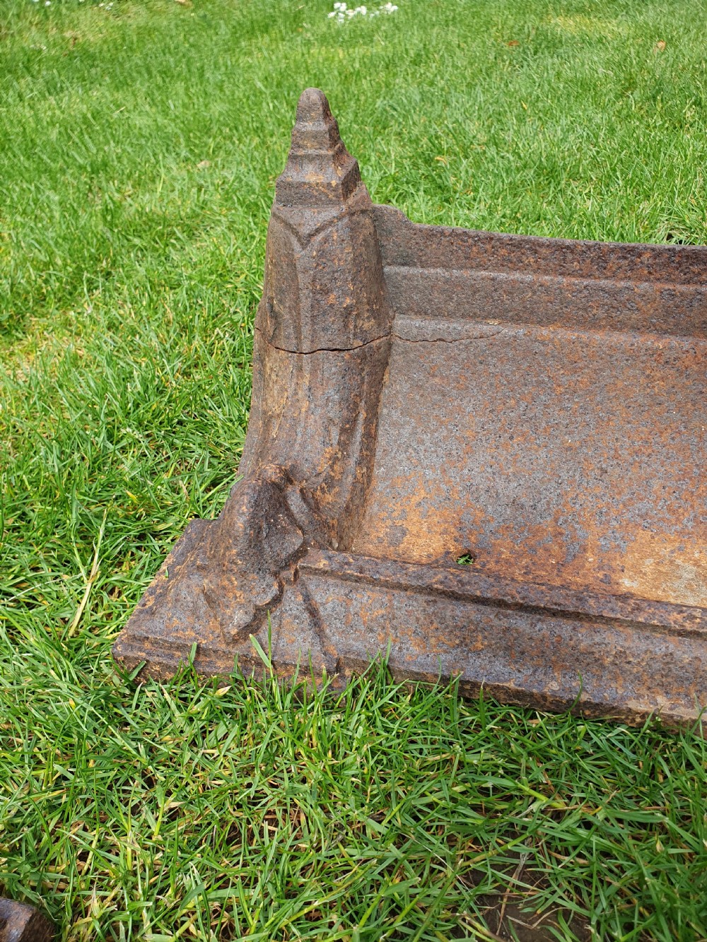 A pair of 19th-century cast iron boot scrapers with moulded trough bases and raised end finials showing natural surface oxidisation. View III
