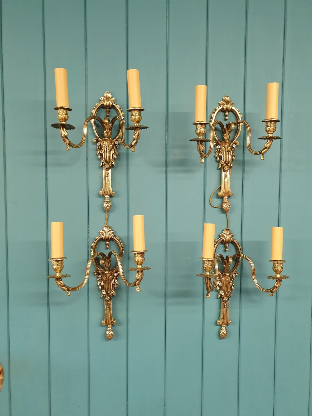 Set of four early 20th century brass wall lights with leaf and acorn design.