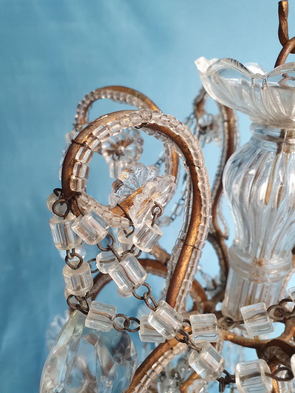 A twelve-arm gilt metal chandelier featuring cut glass crystal drops and beaded swags. View V